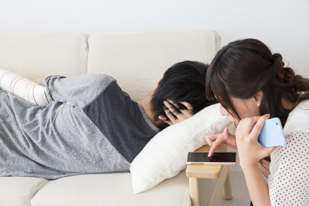 スマホを勝手に見る女性の画像